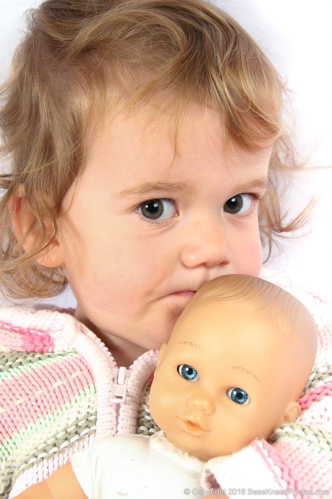 girl hugging her doll at a family photoshoot