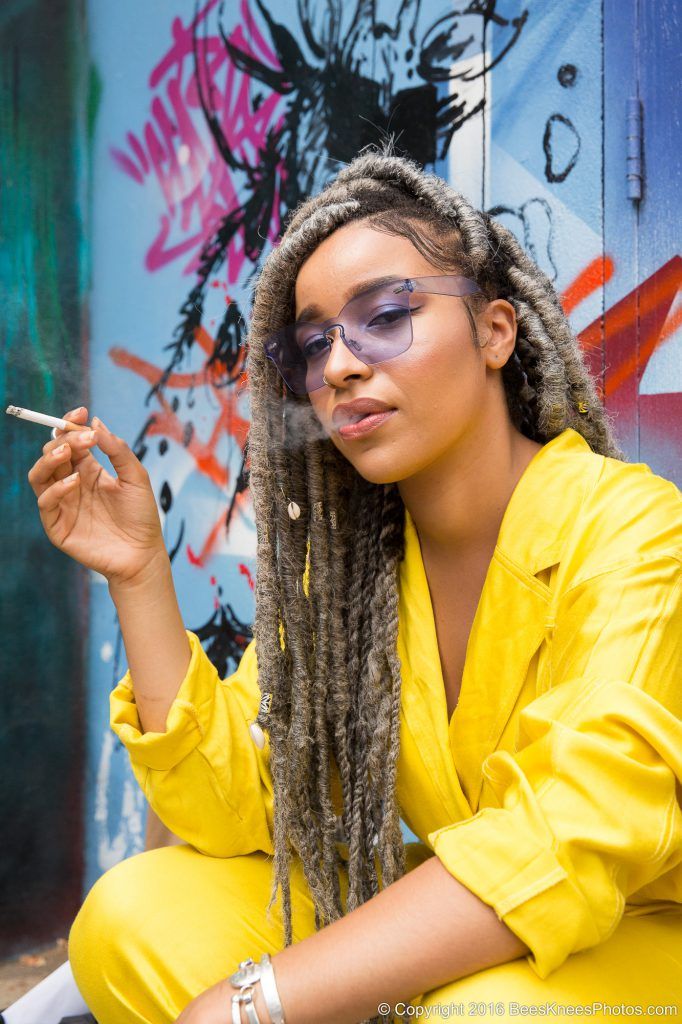 woman in yellow wearing purple sunglasses