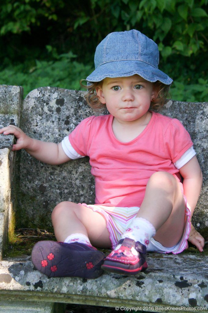 young girl dressed in pink with a blue hat