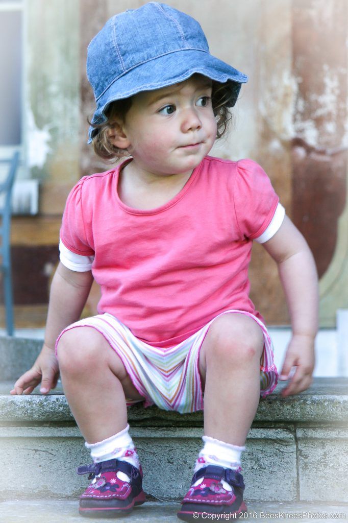 young girl sat on some steps during an outdoor family photoshoot